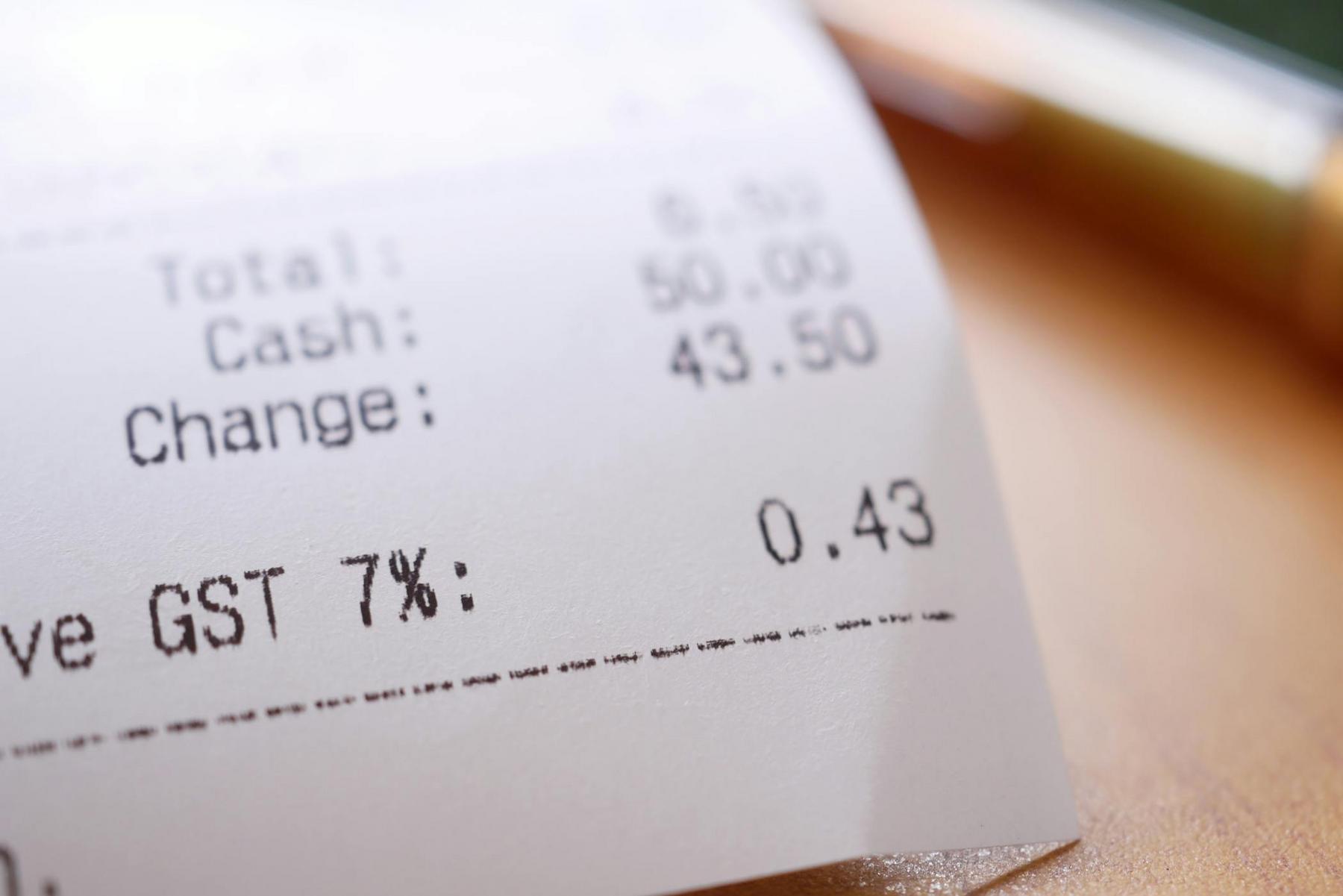 Close-up of a printed receipt showing total amount, cash paid, change given, and a GST (7%) amount of 0.43.
